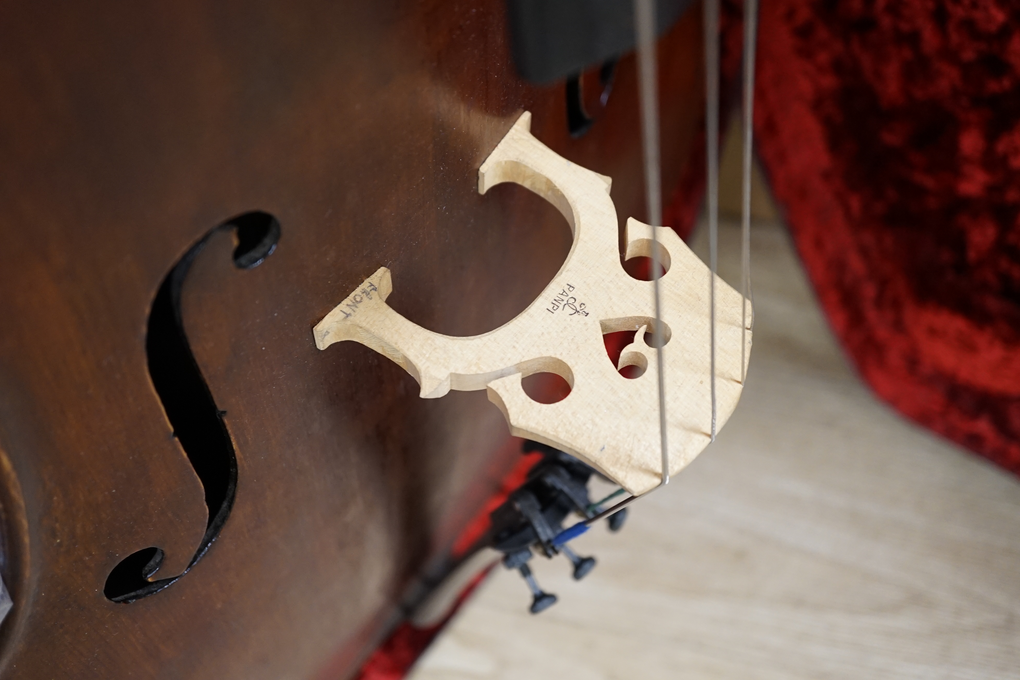 A cased early 20th century ‘cello, length of body 75.5cm, with two spare bridges, and spare strings